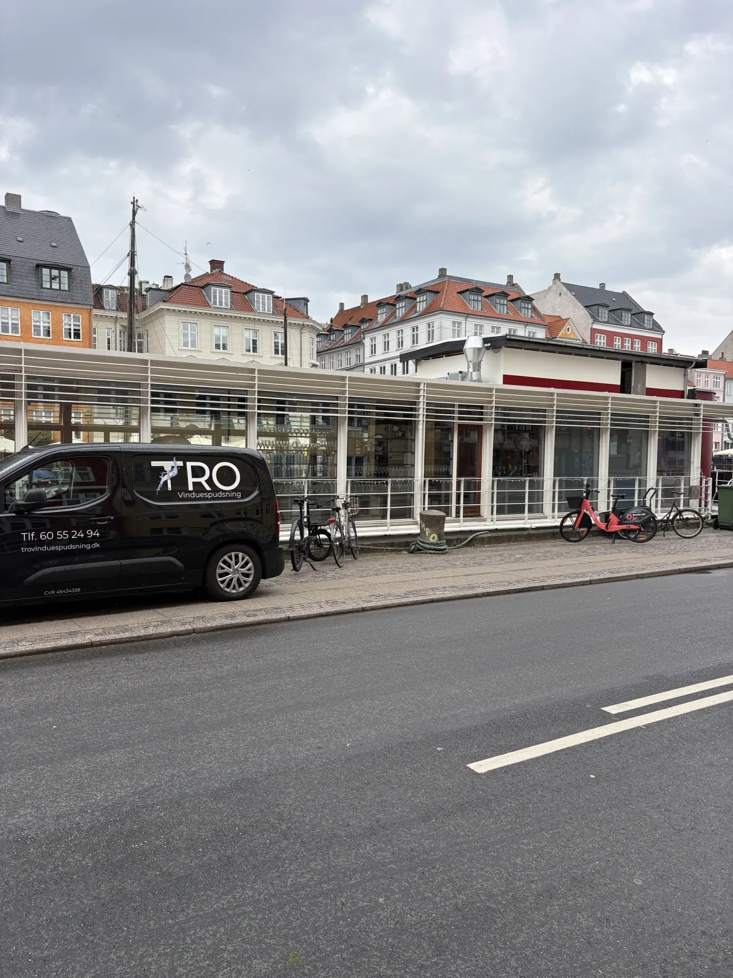 Vinduespudser fra TRO Vinduespudsning i arbejde med skraber og spand